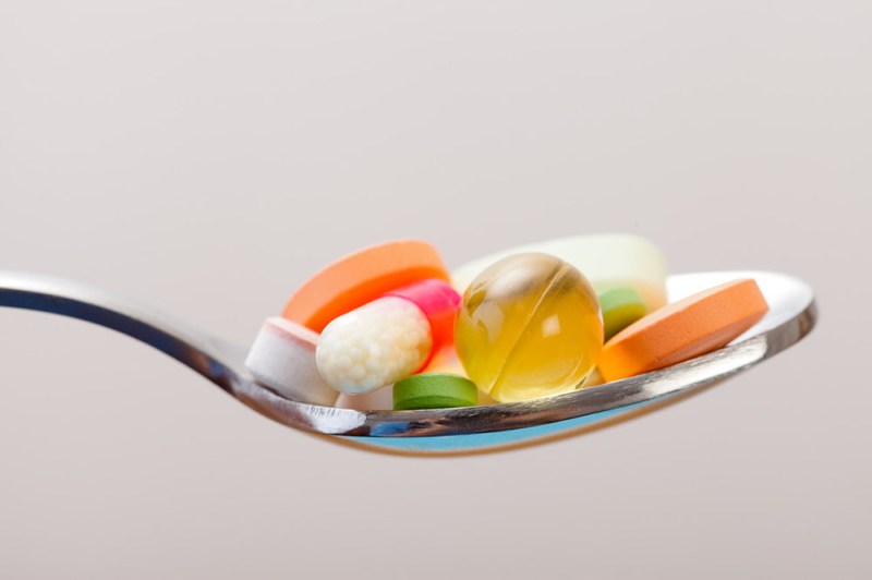 A spoonful of assorted vitamins and supplements of various shapes and colors | Best Time to Take Vitamins