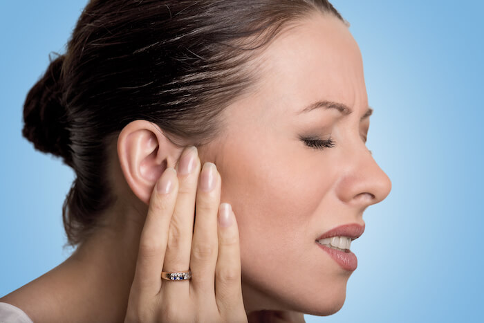 Woman touching her ear in pain. | The Best Remedy for An Ear Infections