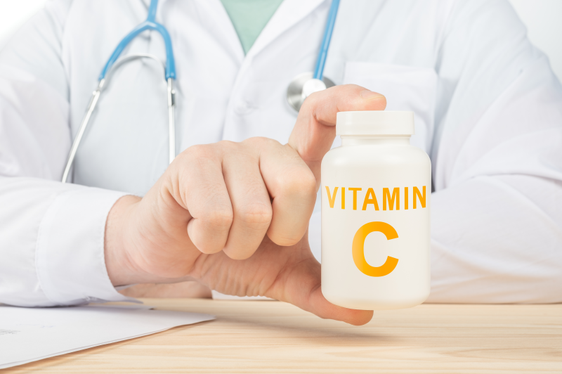 Doctor holding vitamin C supplement container